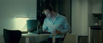 Movie still from “Shame” (2011), directed by Steve McQueen – A man sitting in front of a computer at a table; Medium shot, High angle