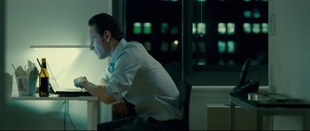Movie still from “Shame” (2011), directed by Steve McQueen – A man sitting in a chair looking at a computer screen; Medium shot, Over the shoulder angle