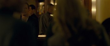 Movie still from “Shame” (2011), directed by Steve McQueen – Two men are sitting at a counter in front of a woman; Medium shot, Over the shoulder angle