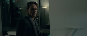 Movie still from “Shame” (2011), directed by Steve McQueen – A man standing in front of a window in a room; Close Up shot, Over the shoulder angle