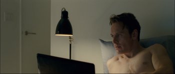 Movie still from “Shame” (2011), directed by Steve McQueen – A man sitting in front of a computer monitor; Close Up shot, Over the shoulder angle