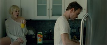 Movie still from “Shame” (2011), directed by Steve McQueen – A man standing in a kitchen next to a box of cereal; Medium shot, Over the shoulder angle