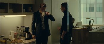 Movie still from “Shame” (2011), directed by Steve McQueen – Two men in suits are having a conversation; Medium shot, Over the shoulder angle