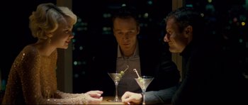 Movie still from “Shame” (2011), directed by Steve McQueen – A man sitting at a table with two martini glasses; Medium shot, Over the shoulder angle