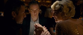 Movie still from “Shame” (2011), directed by Steve McQueen – A group of people sitting at a table talking to each other; Close Up shot, Over the shoulder angle