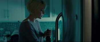 Movie still from “Shame” (2011), directed by Steve McQueen – A woman is looking in the mirror in a kitchen; Medium shot, Over the shoulder angle