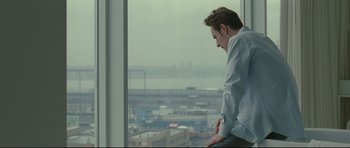 Movie still from “Shame” (2011), directed by Steve McQueen – A man looking out of a window at a city; Medium shot, Over the shoulder angle