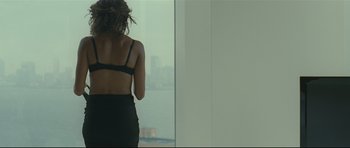 Movie still from “Shame” (2011), directed by Steve McQueen – A woman standing in front of a large window; Medium shot, Over the shoulder angle