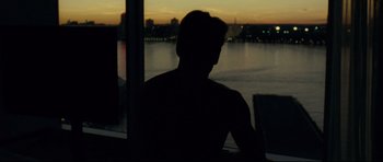 Movie still from “Shame” (2011), directed by Steve McQueen – A man sitting in front of a window at night; Wide shot, Over the shoulder angle