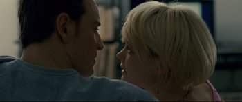 Movie still from “Shame” (2011), directed by Steve McQueen – A man and a woman face to face in front of a bookshelf; Close Up shot, Low angle
