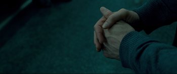 Movie still from “Shame” (2011), directed by Steve McQueen – Two hands clasped together in a dark room; Extreme Close Up shot, Overhead angle