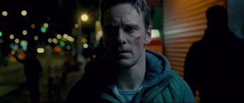 Movie still from “Shame” (2011), directed by Steve McQueen – A person wearing a hooded jacket; Close Up shot, Over the shoulder angle