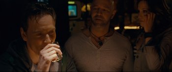 Movie still from “Shame” (2011), directed by Steve McQueen – Two men standing next to each other holding drinks; Close Up shot, Over the shoulder angle