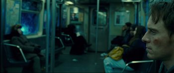 Movie still from “Shame” (2011), directed by Steve McQueen – A blurry picture of a subway car with people sitting on it; Medium shot, Over the shoulder angle