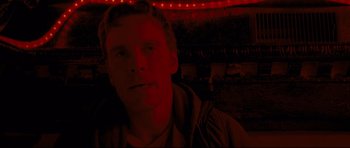 Movie still from “Shame” (2011), directed by Steve McQueen – A man with red lights in the background; Close Up shot, Low angle