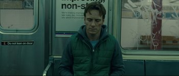 Movie still from “Shame” (2011), directed by Steve McQueen – A man sitting on top of a train; Medium shot, Low angle