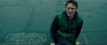 Movie still from “Shame” (2011), directed by Steve McQueen – A man sitting on the ground with his head in his hands; Medium shot, Overhead angle