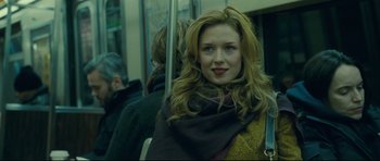 Movie still from “Shame” (2011), directed by Steve McQueen – A woman sitting on a train with a scarf around her neck; Close Up shot, Over the shoulder angle