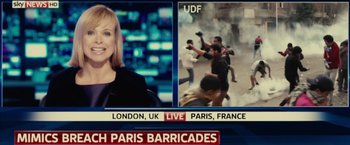 Movie still from “Edge of Tomorrow” (2014), directed by Doug Liman – A television screen showing a news anchor and a group of people; Close Up shot, Over the shoulder angle