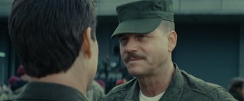 Movie still from “Edge of Tomorrow” (2014), directed by Doug Liman – A man in a military uniform talking to another man in fatigues; Close Up shot, Over the shoulder angle