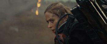 Movie still from “Edge of Tomorrow” (2014), directed by Doug Liman – A person with a gun in a field; Close Up shot, Over the shoulder angle