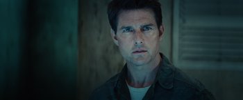 Movie still from “Edge of Tomorrow” (2014), directed by Doug Liman – A man in a green shirt looking at the camera; Close Up shot, Low angle