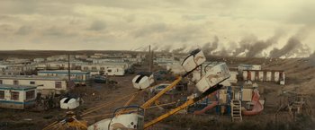 Movie still from “Edge of Tomorrow” (2014), directed by Doug Liman – An amusement park with a lot of cars parked on the ground; Extreme Wide shot, High angle