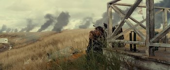 Movie still from “Edge of Tomorrow” (2014), directed by Doug Liman – A man sitting in a boat on top of a grass covered field; Wide shot, Low angle