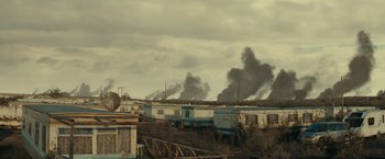 Movie still from “Edge of Tomorrow” (2014), directed by Doug Liman – A group of trailers that are in the grass; Extreme Wide shot, High angle
