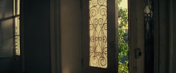 Movie still from “Edge of Tomorrow” (2014), directed by Doug Liman – A door with a wrought - iron window in it; Medium shot, High angle