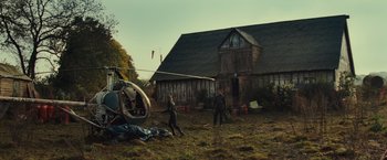Movie still from “Edge of Tomorrow” (2014), directed by Doug Liman – Two people are walking in a field near an old barn; Extreme Wide shot, Low angle