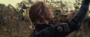 Movie still from “Edge of Tomorrow” (2014), directed by Doug Liman – A woman with long hair is looking up at the sky; Close Up shot, Over the shoulder angle