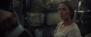 Movie still from “Edge of Tomorrow” (2014), directed by Doug Liman – A woman standing in front of a trash can; Close Up shot, Over the shoulder angle