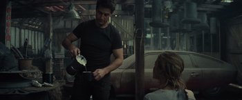 Movie still from “Edge of Tomorrow” (2014), directed by Doug Liman – A man pouring a drink into a woman's mouth; Medium shot, Over the shoulder angle