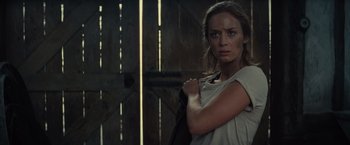 Movie still from “Edge of Tomorrow” (2014), directed by Doug Liman – A woman standing in front of a wooden wall; Medium shot, Over the shoulder angle