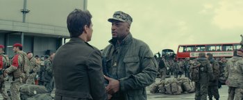 Movie still from “Edge of Tomorrow” (2014), directed by Doug Liman – A man in fatigues talking to a man in military fatigues holding a gun; Medium shot, Over the shoulder angle