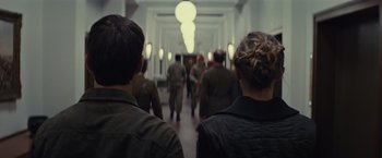 Movie still from “Edge of Tomorrow” (2014), directed by Doug Liman – A group of people walking down a hall way; Close Up shot, Over the shoulder angle