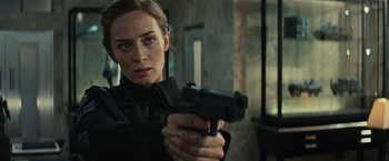 Movie still from “Edge of Tomorrow” (2014), directed by Doug Liman – A woman is holding a gun in her hand; Close Up shot, Over the shoulder angle
