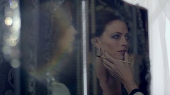 Movie still from “Sherlock” (2010), created by Steven Moffat – A beautiful woman holding a brush in front of a mirror; Close Up shot, Over the shoulder angle