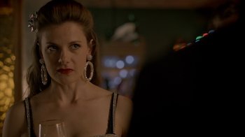 Movie still from “Sherlock” (2010), created by Steven Moffat – A woman in a black and white dress holding a glass of wine; Close Up shot, Over the shoulder angle