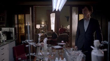 A man in a suit standing in front of a living room