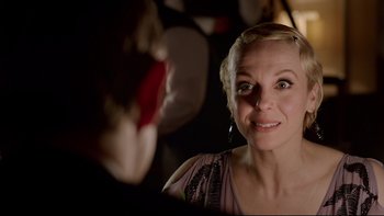 Movie still from “Sherlock” (2010), created by Steven Moffat – A woman looking into a mirror with a flower in front of her face; Close Up shot, Over the shoulder angle
