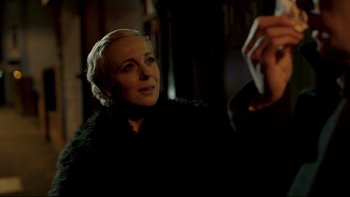 Movie still from “Sherlock” (2010), created by Steven Moffat – A woman in a black jacket is taking a picture; Close Up shot, Over the shoulder angle