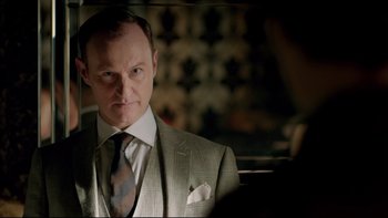 Movie still from “Sherlock” (2010), created by Steven Moffat – A man in a suit and tie looking at the camera; Close Up shot, Over the shoulder angle