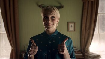 Movie still from “Sherlock” (2010), created by Steven Moffat – A woman giving two thumbs up while wearing a blue shirt; Medium shot, Over the shoulder angle