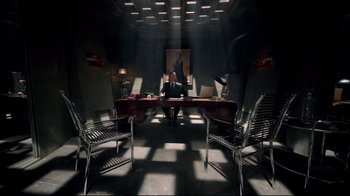 Movie still from “Sherlock” (2010), created by Steven Moffat – A man sitting at a desk in a dark room; Wide shot, High angle
