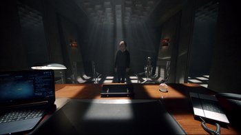 Movie still from “Sherlock” (2010), created by Steven Moffat – A man standing in a dark room in front of a desk; Wide shot, High angle