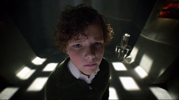 Movie still from “Sherlock” (2010), created by Steven Moffat – A young boy with curly hair is looking at the camera; Close Up shot, High angle