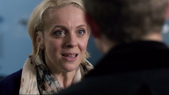 Movie still from “Sherlock” (2010), created by Steven Moffat – A woman is looking at a man in a business suit; Close Up shot, Over the shoulder angle
