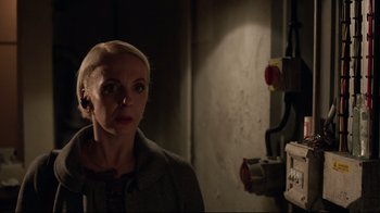 Movie still from “Sherlock” (2010), created by Steven Moffat – A woman standing next to a power box in a dark room; Close Up shot, Low angle